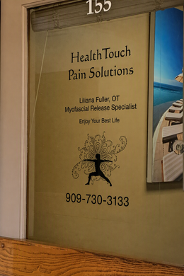 HealthTouch Pain Solutions storefront sign with phone number and massage-themed graphic on a tan windowed door