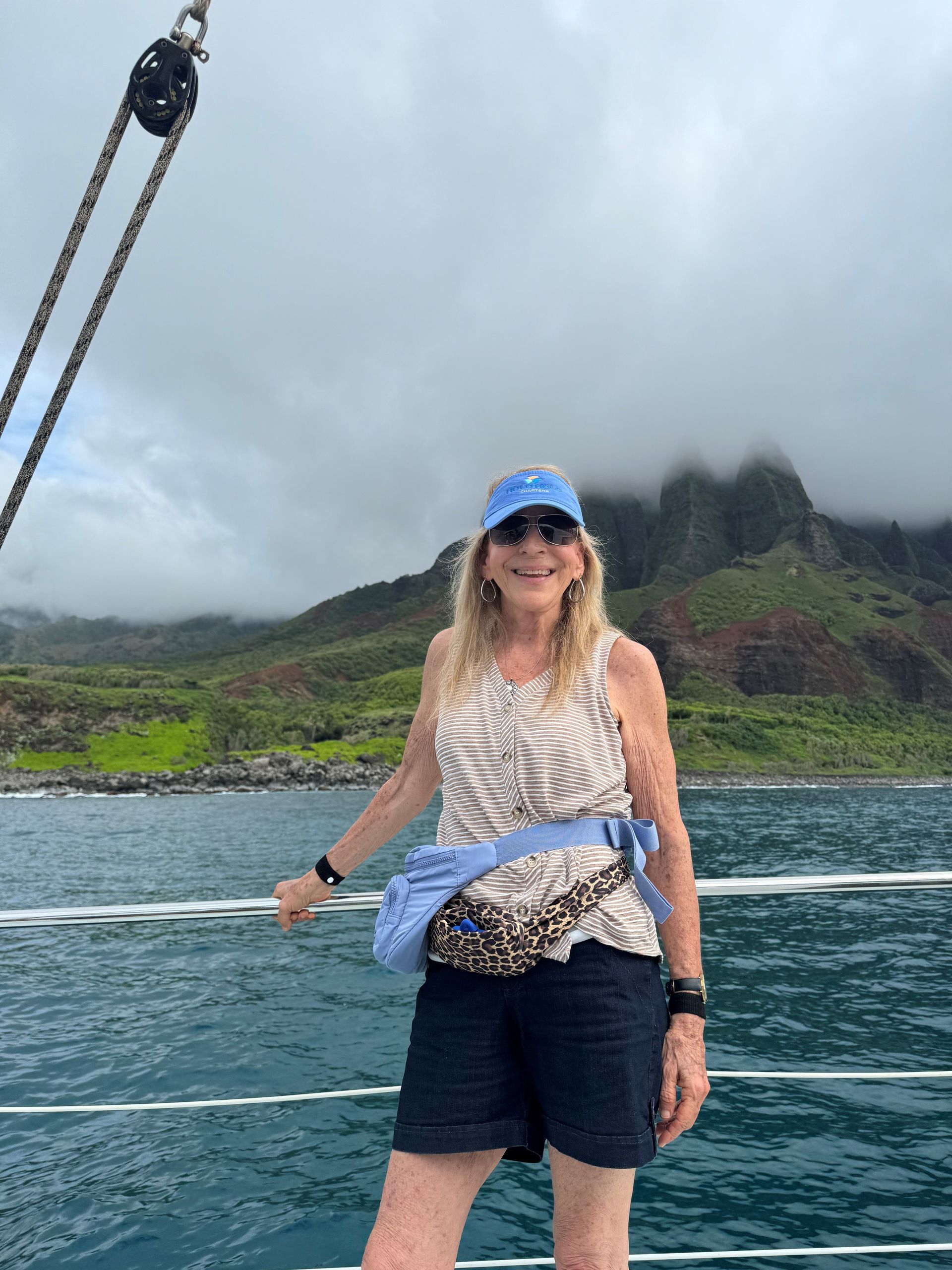 A woman is standing on a boat in the ocean.