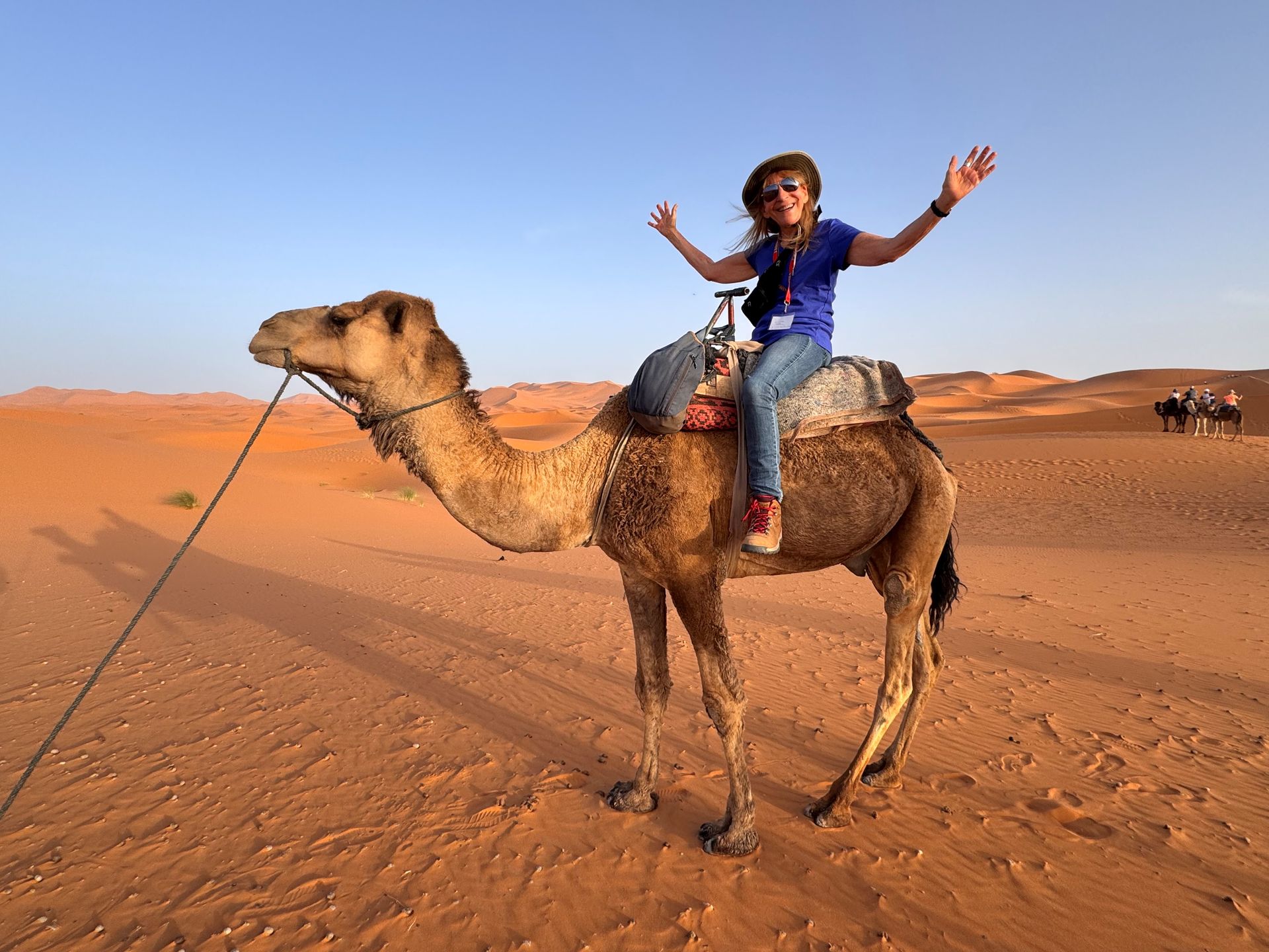A woman is riding a camel in the desert.
