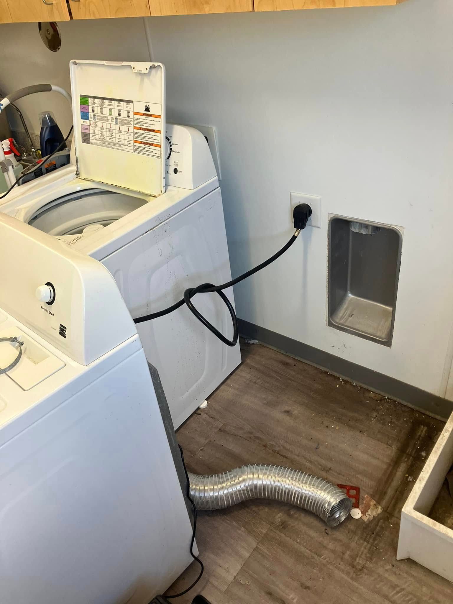 A washer and dryer are sitting next to each other in a laundry room.