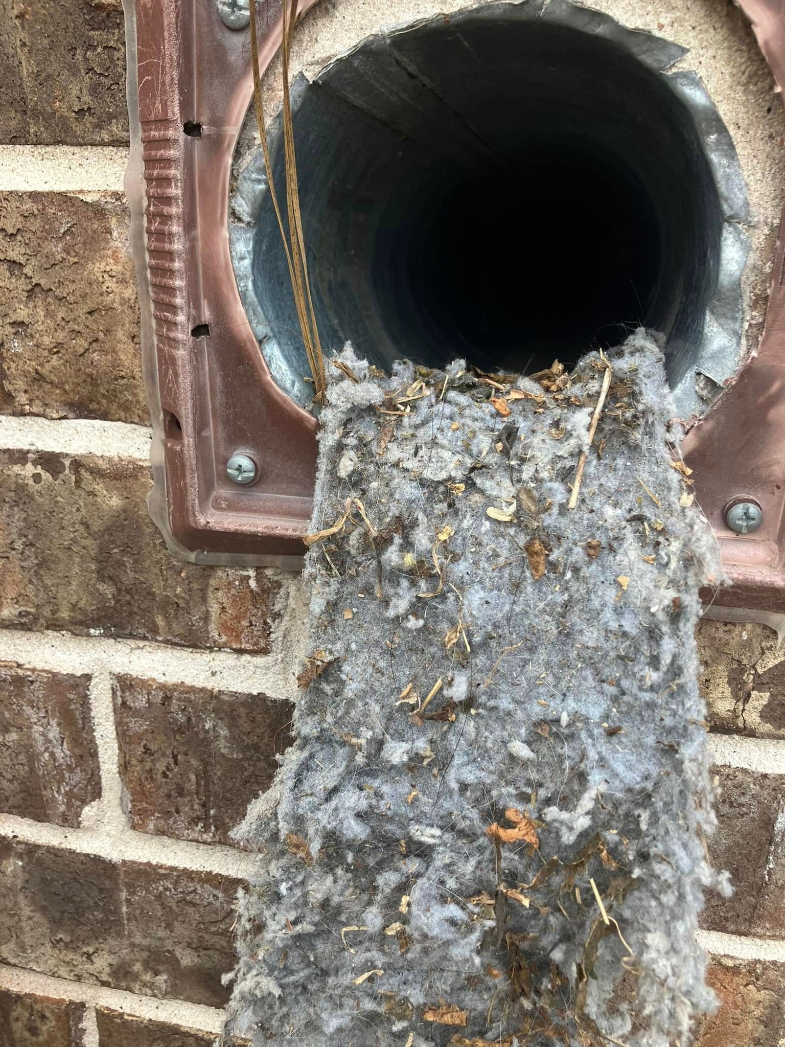 A close up of a duct with a lot of dust coming out of it.