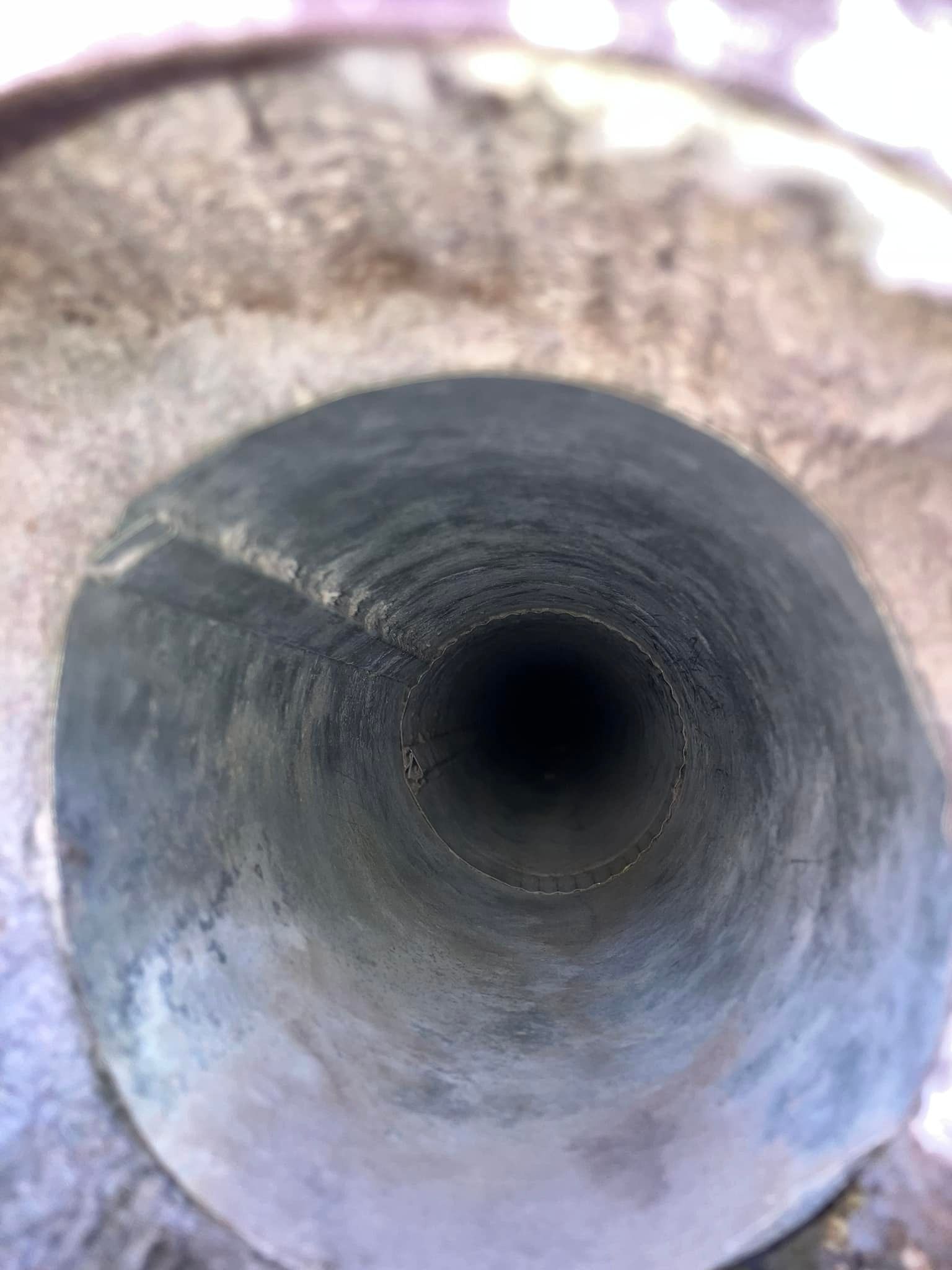 A close up of a hole in a metal pipe.