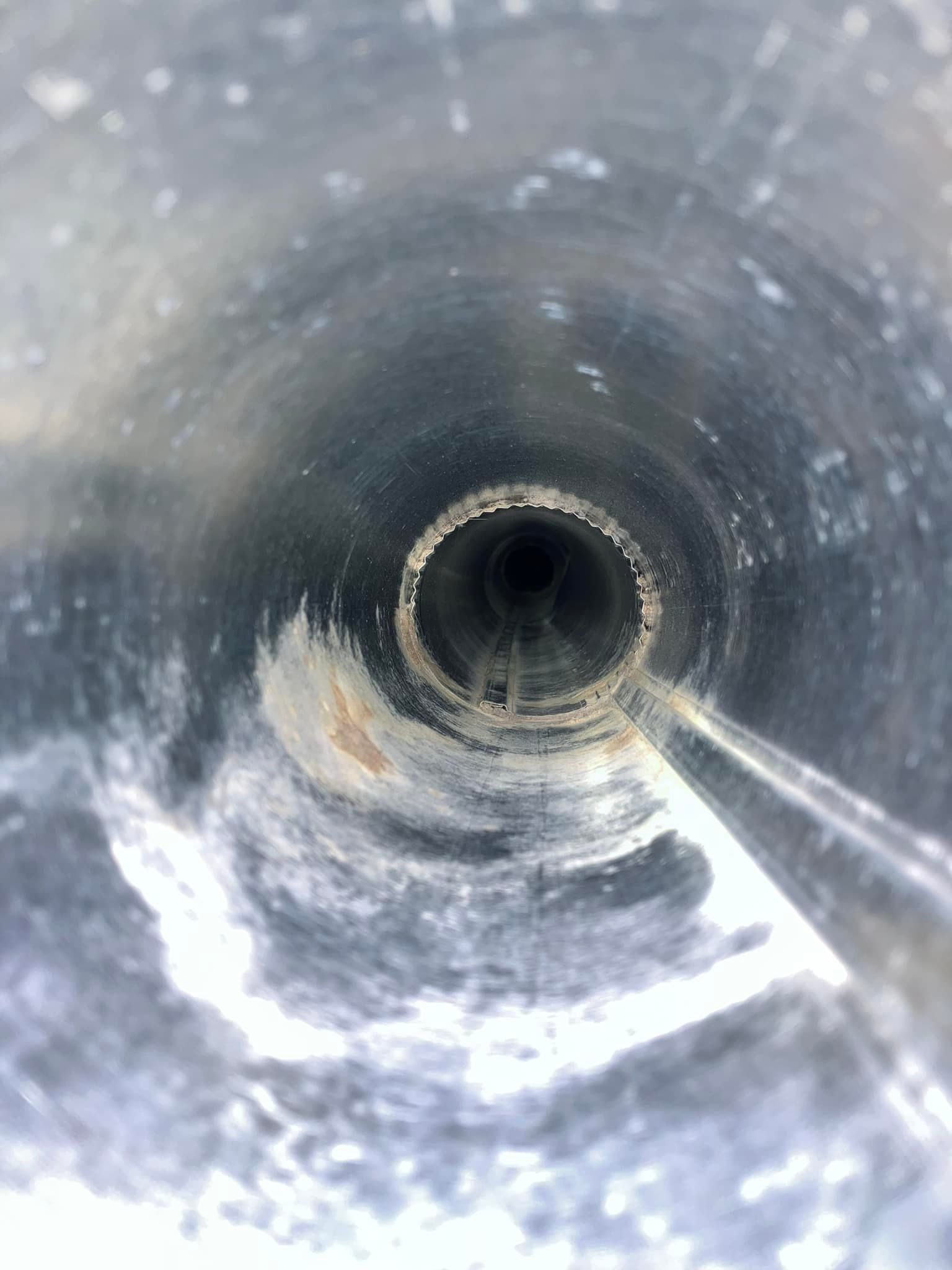 A close up of a metal pipe with a hole in the middle.