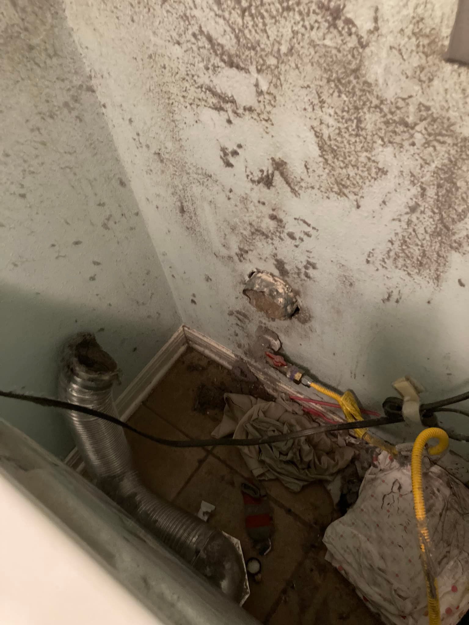 A room with a lot of dirty walls and a drain pipe.