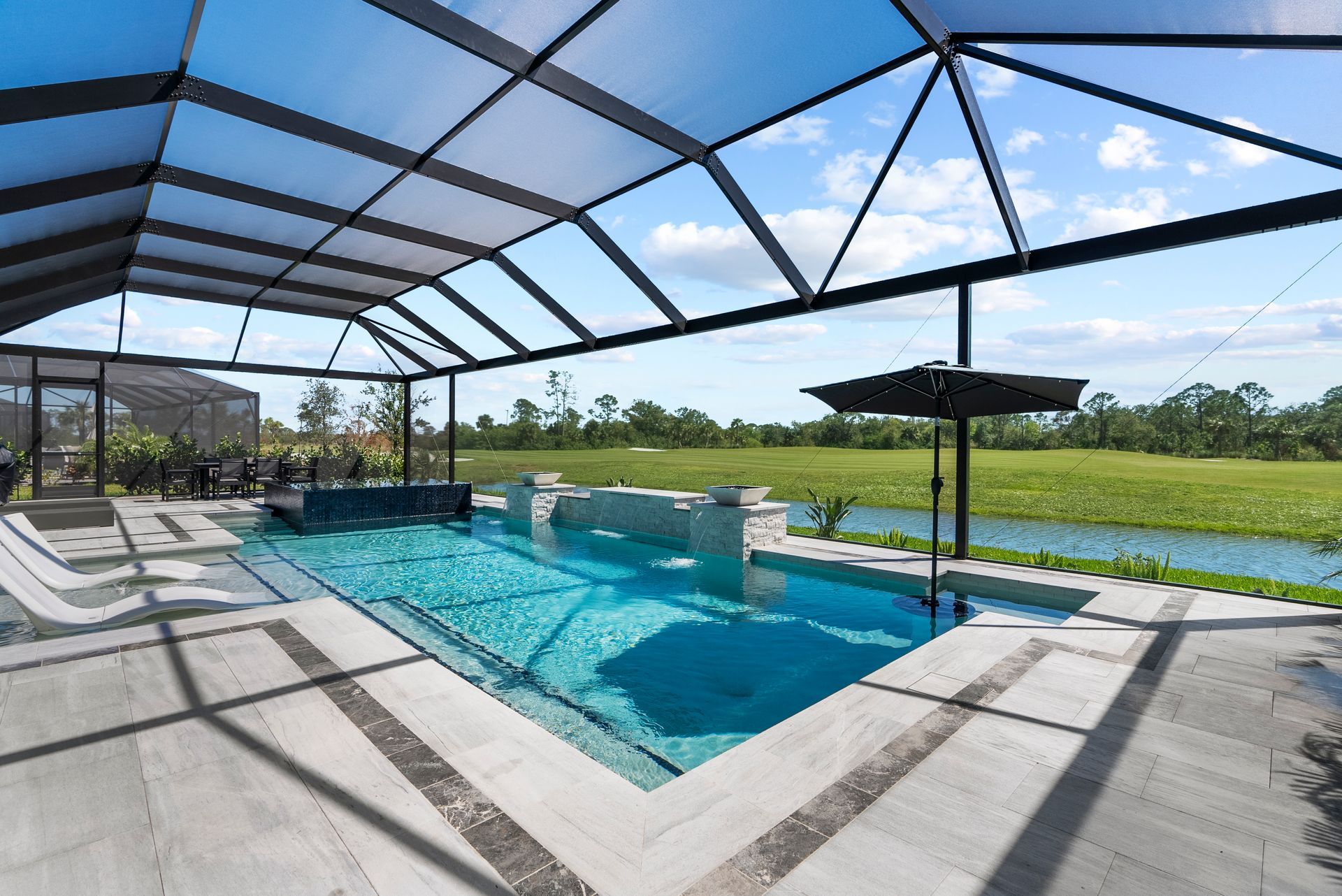 Screened-in backyard pool with turquoise water, lounge chairs, and a grassy yard under a blue sky