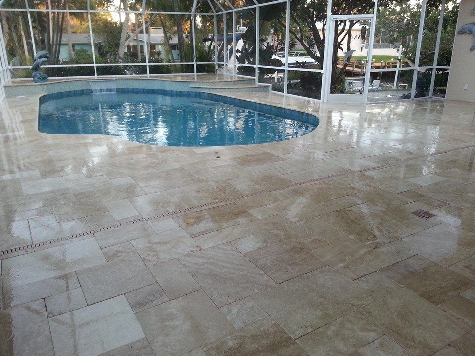 Patio with a small blue pool and white-tiled floor under a screened enclosure