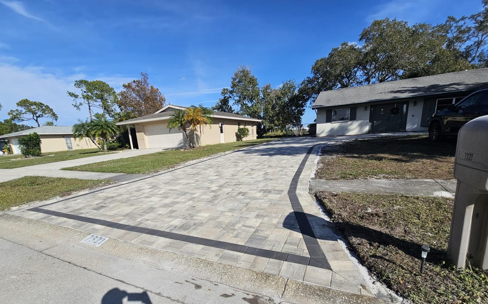 Suburban driveway between single-story homes on a sunny day