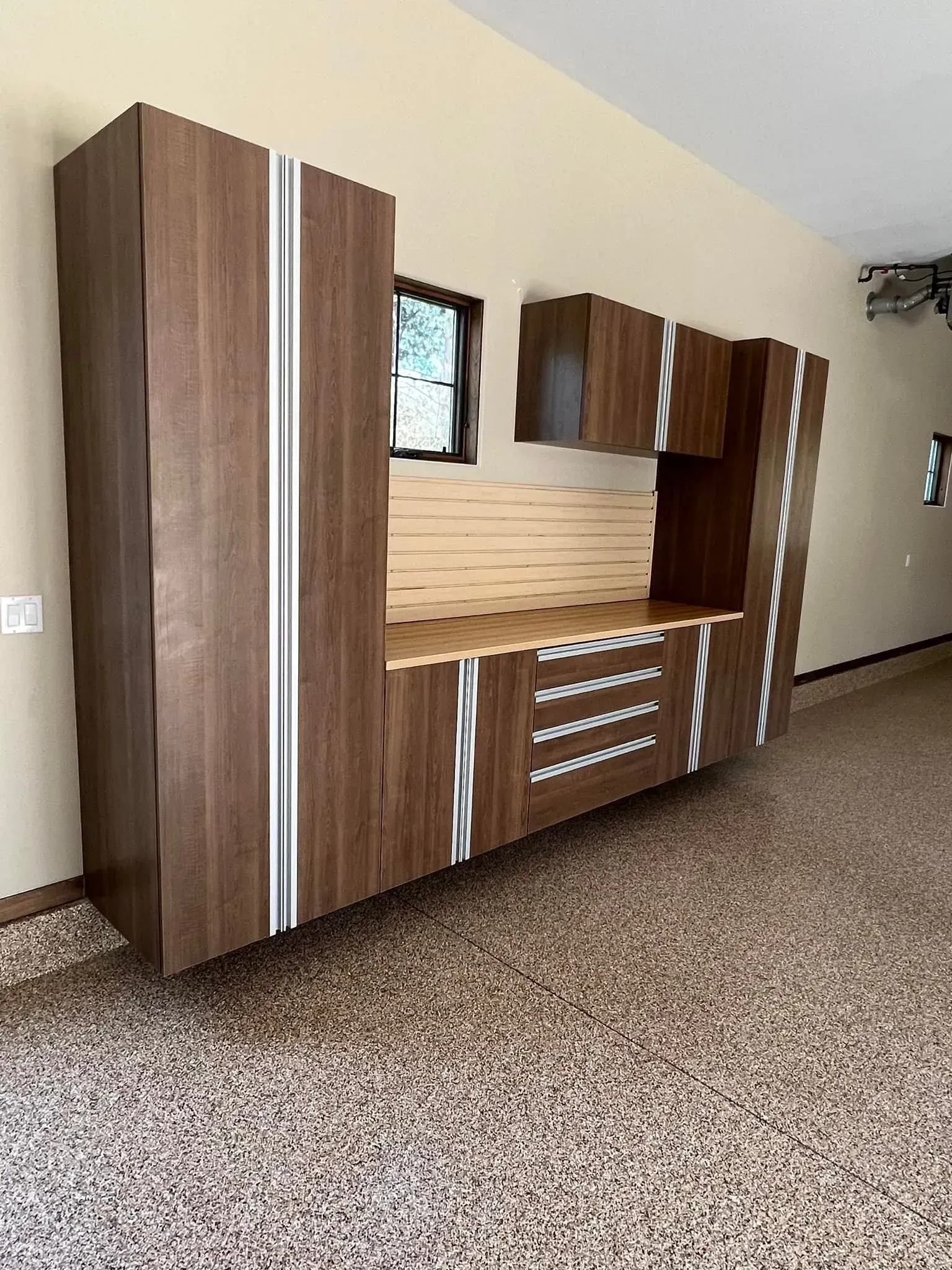 Wooden wall unit with cabinets and drawers in an empty hallway or room