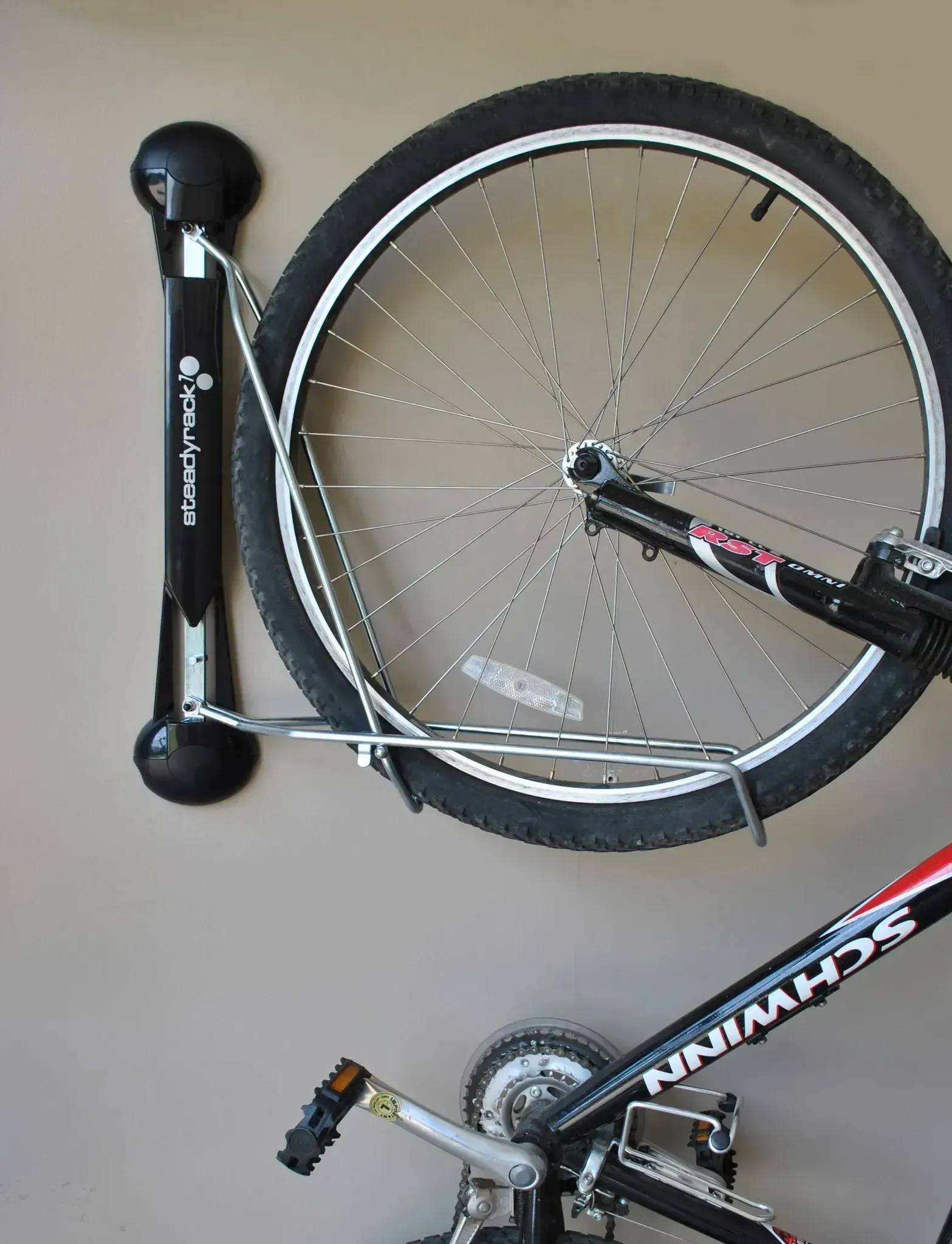 Bicycle mounted vertically on a wall rack, with front wheel and frame visible.