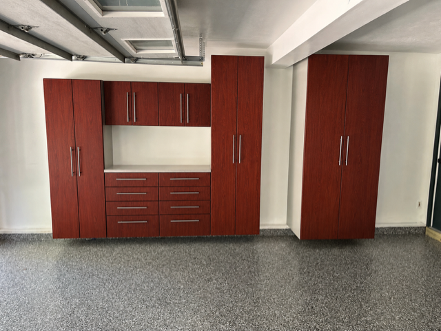 Wooden cabinets and drawers installed against a white wall in a garage or utility room