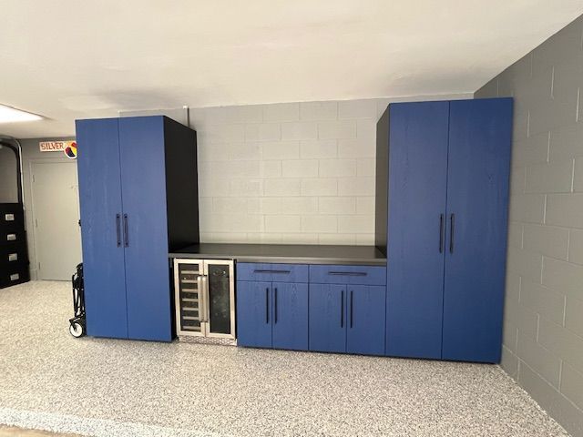 Basement utility room with blue cabinets, countertop, and white tiled walls