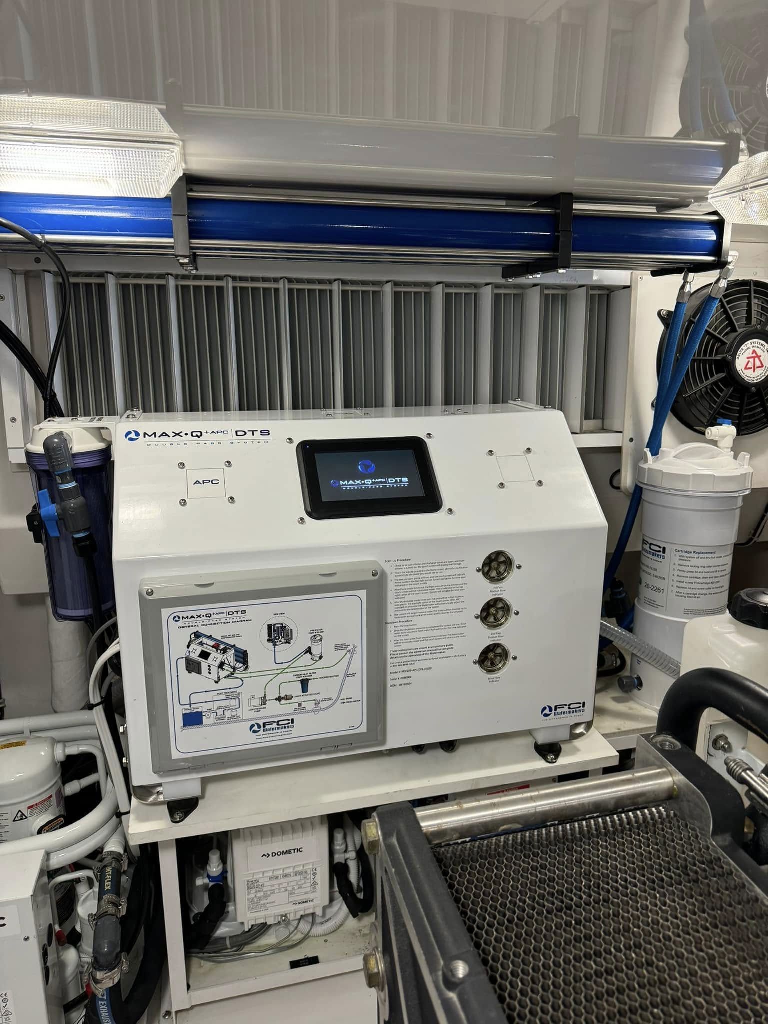White industrial machine with a small touchscreen and pipes in a workshop setting