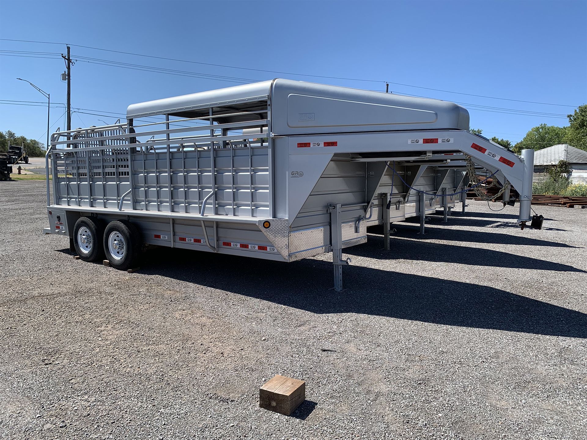 A white trailer is parked in a gravel lot.