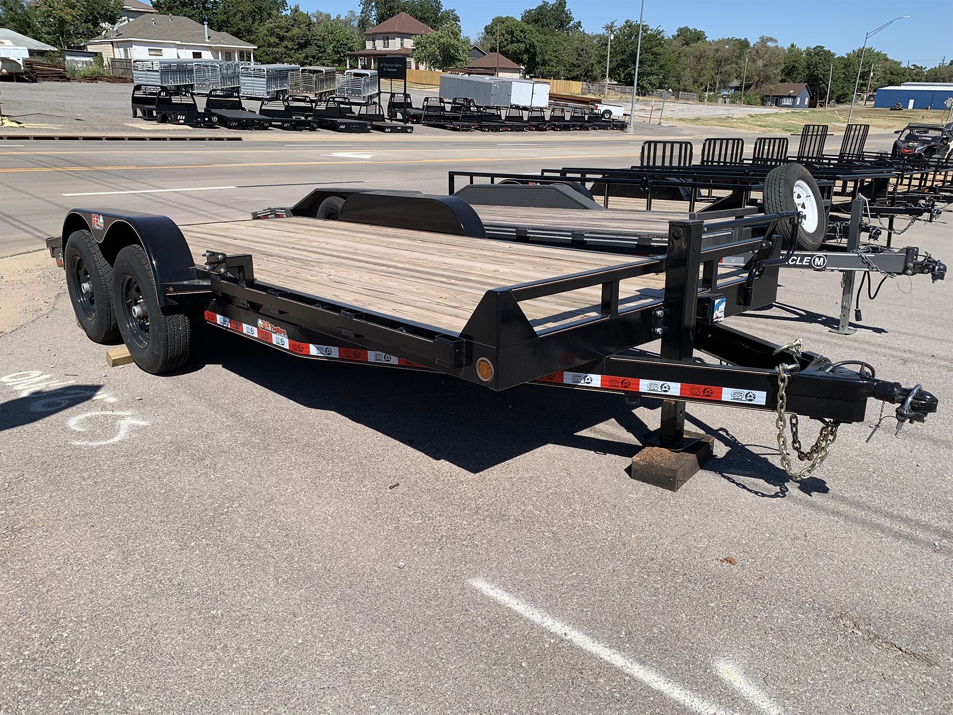 A flatbed trailer is parked in a parking lot.