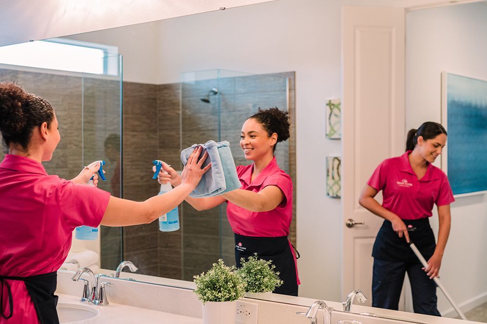 A pink mop is being used to clean a tiled floor.