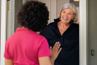 Two female cleaners are standing next to each other in a room.