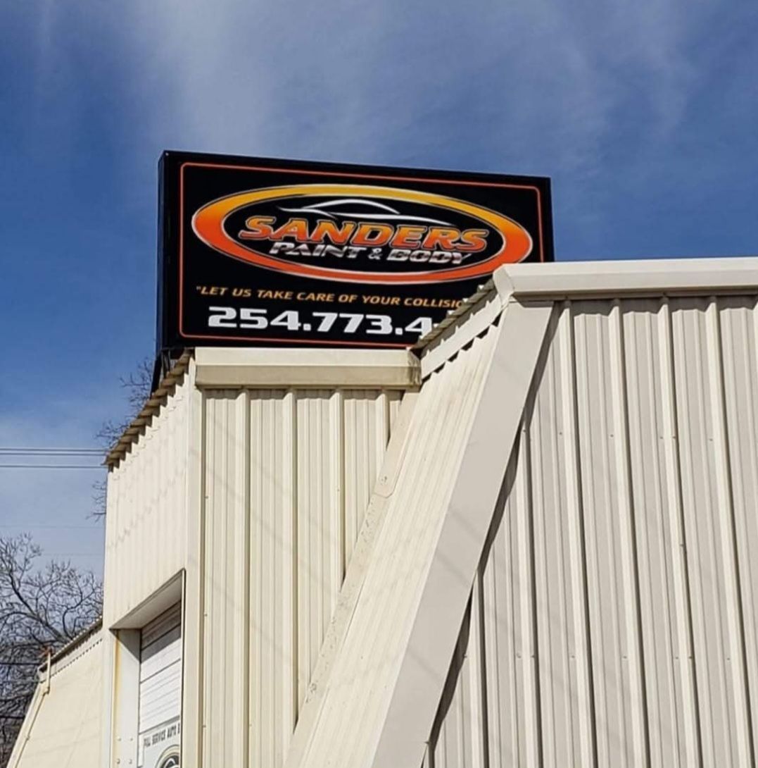 Sanders sign atop a beige building against a blue sky