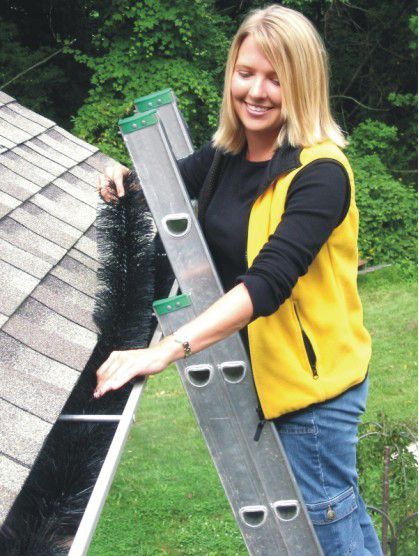 a woman cleaning a gutter