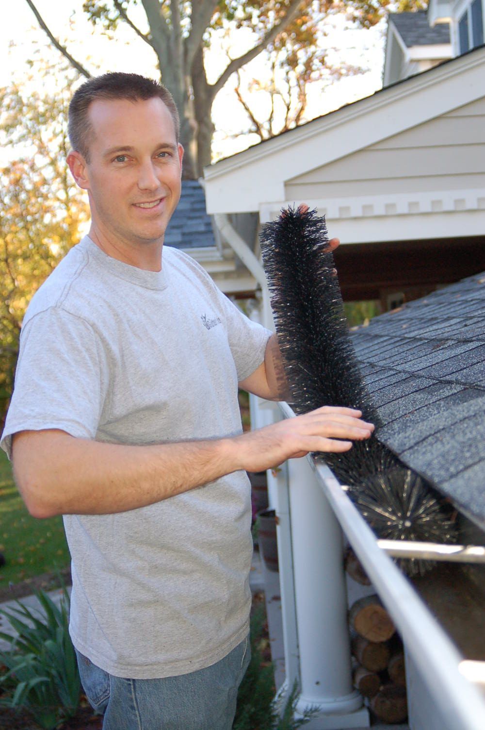 a man holding a brush on a roof