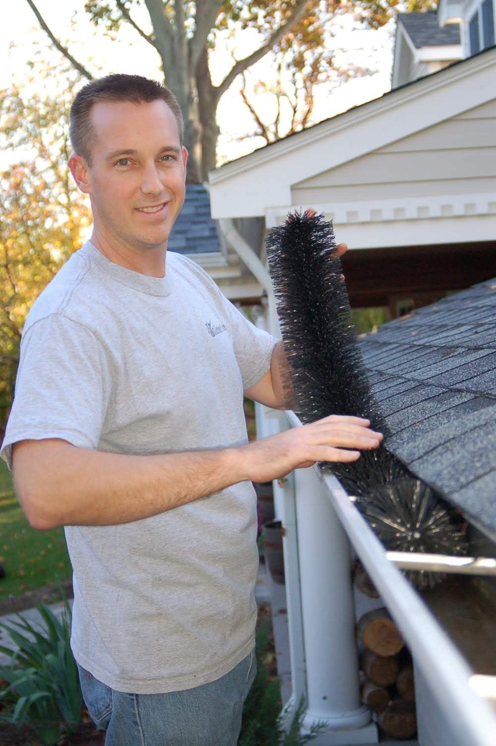a man holding a brush on a roof