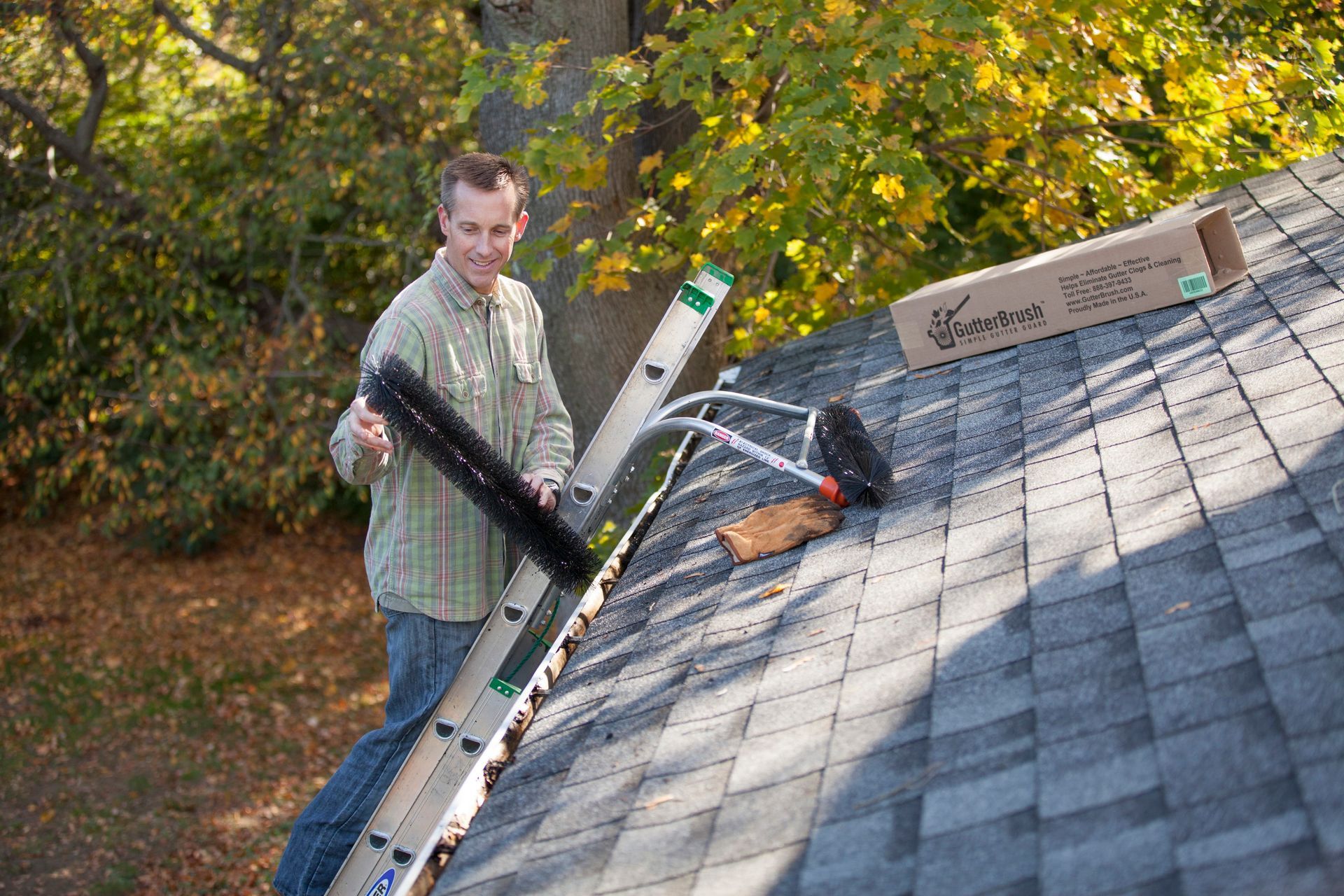A man cleaning a gutter