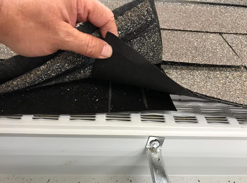 a hand holding a black piece of paper