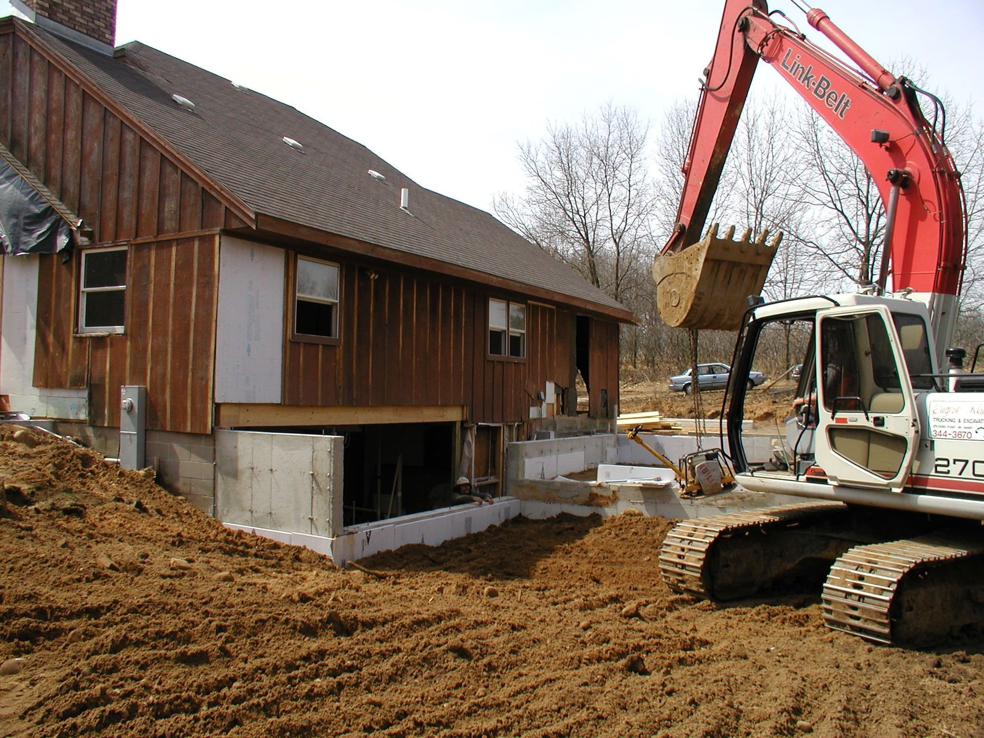 Excavator beside an old house