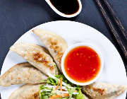 Fried jiaozi with chilli sauce and salad