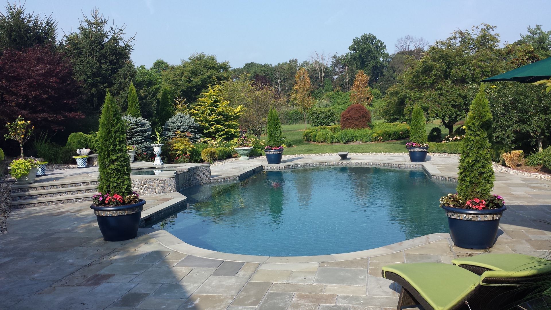A large swimming pool with a green umbrella in the background