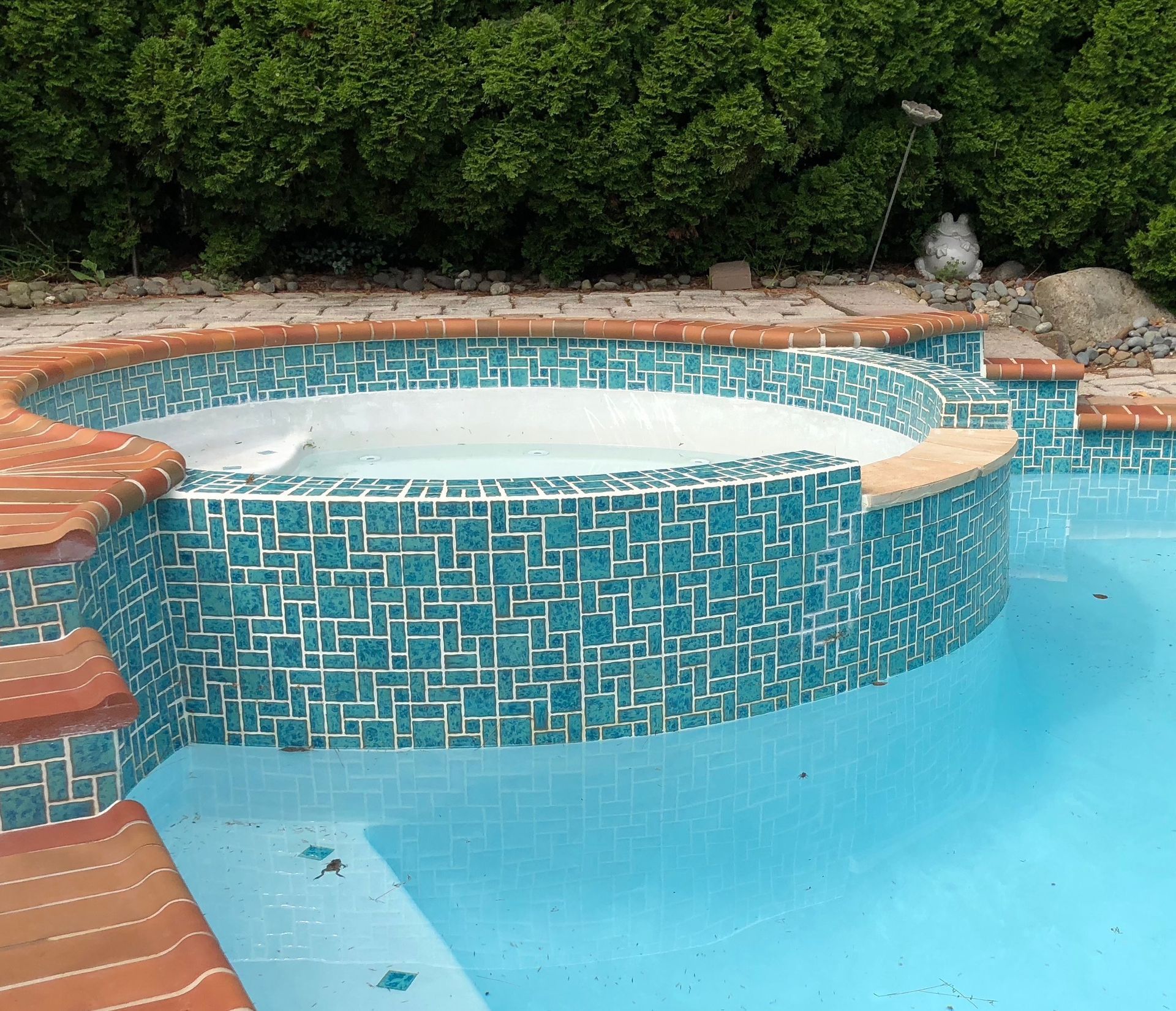 A swimming pool with a hot tub in the middle
