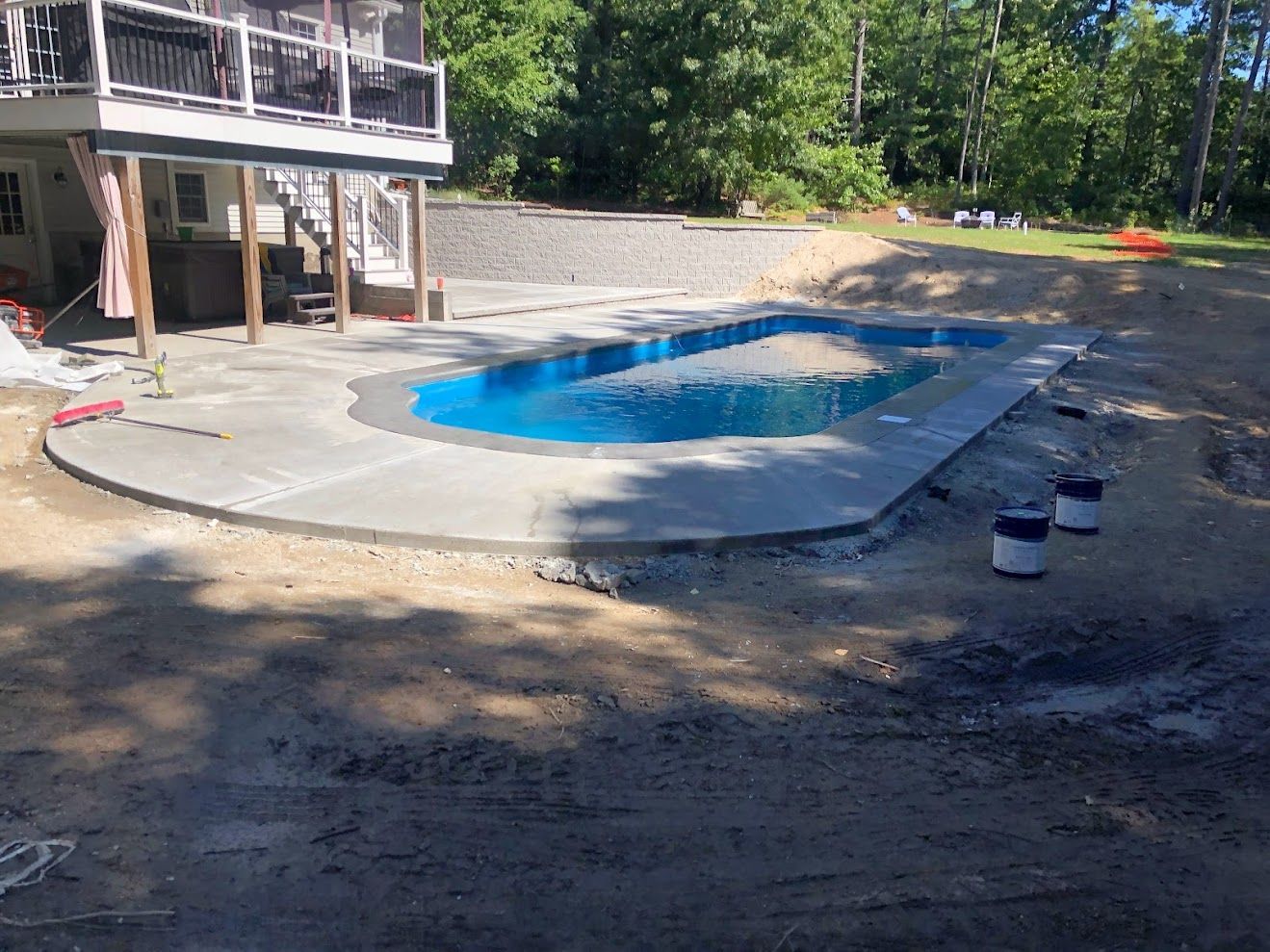 A large swimming pool is being built in the backyard of a house.