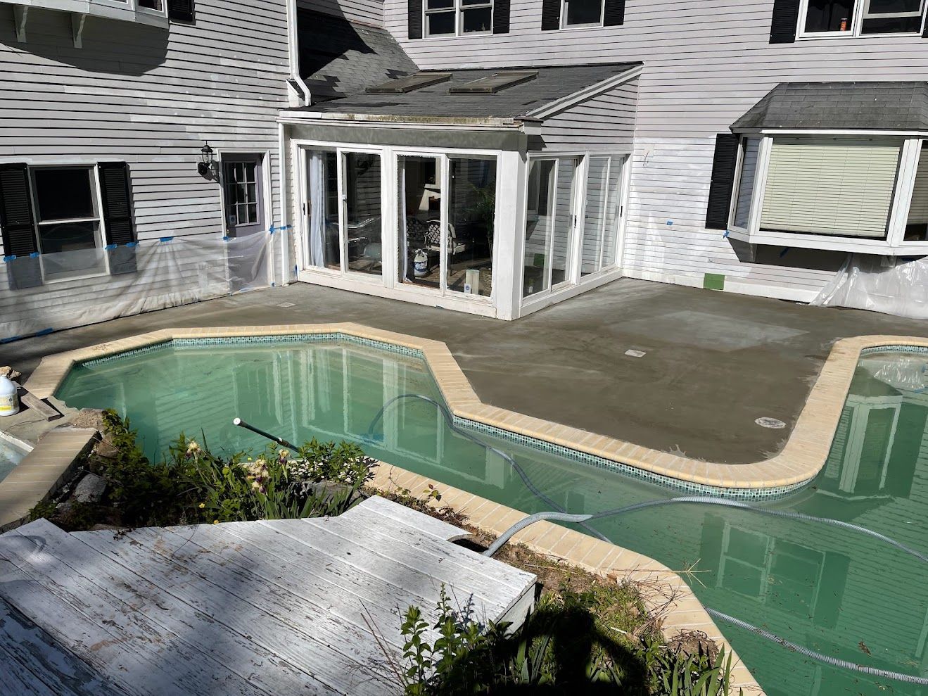 A large house with a swimming pool in front of it