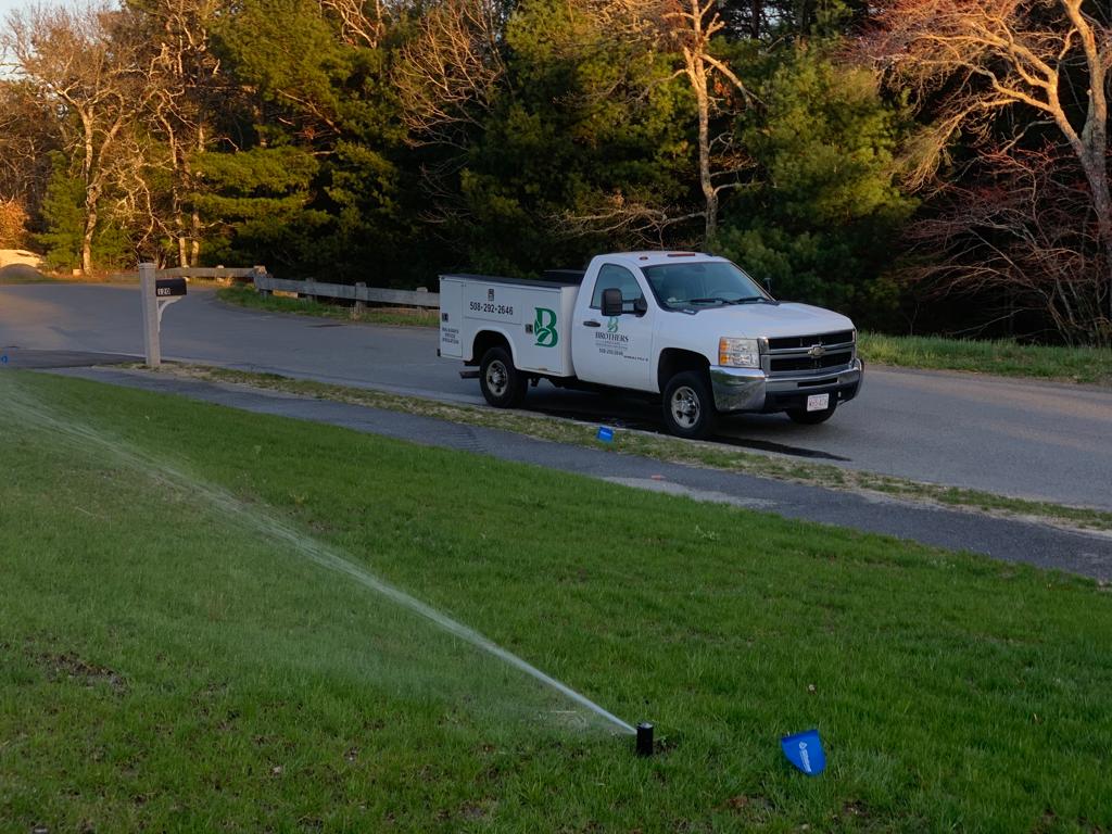 lawn irrigation with a white company truck in the background