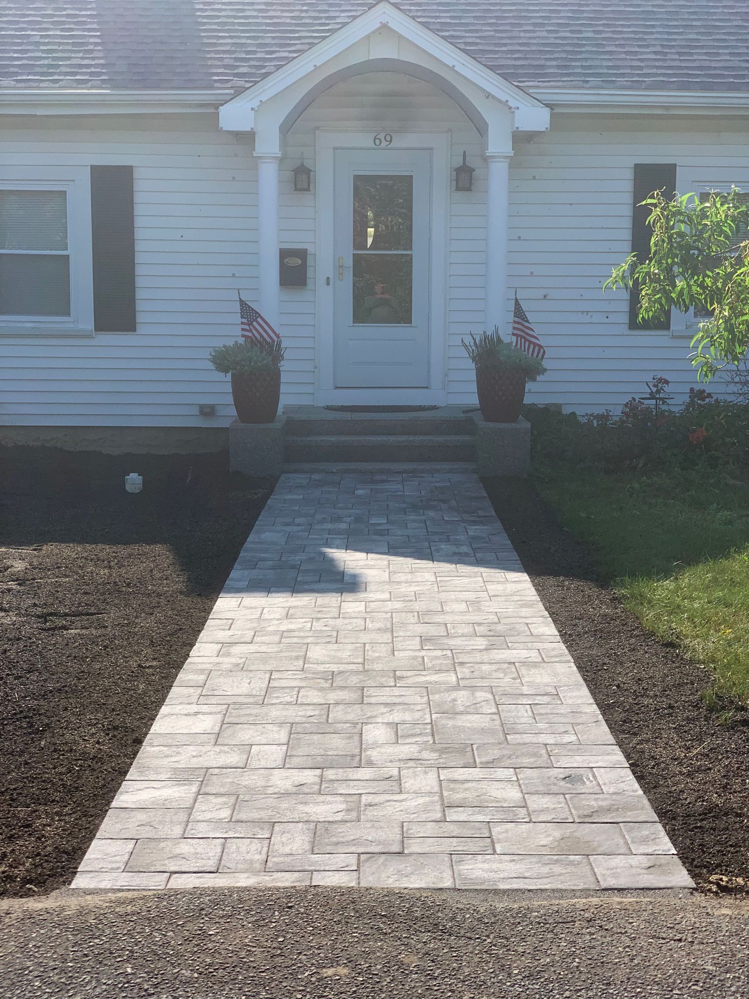 A white house with a walkway leading to the front door