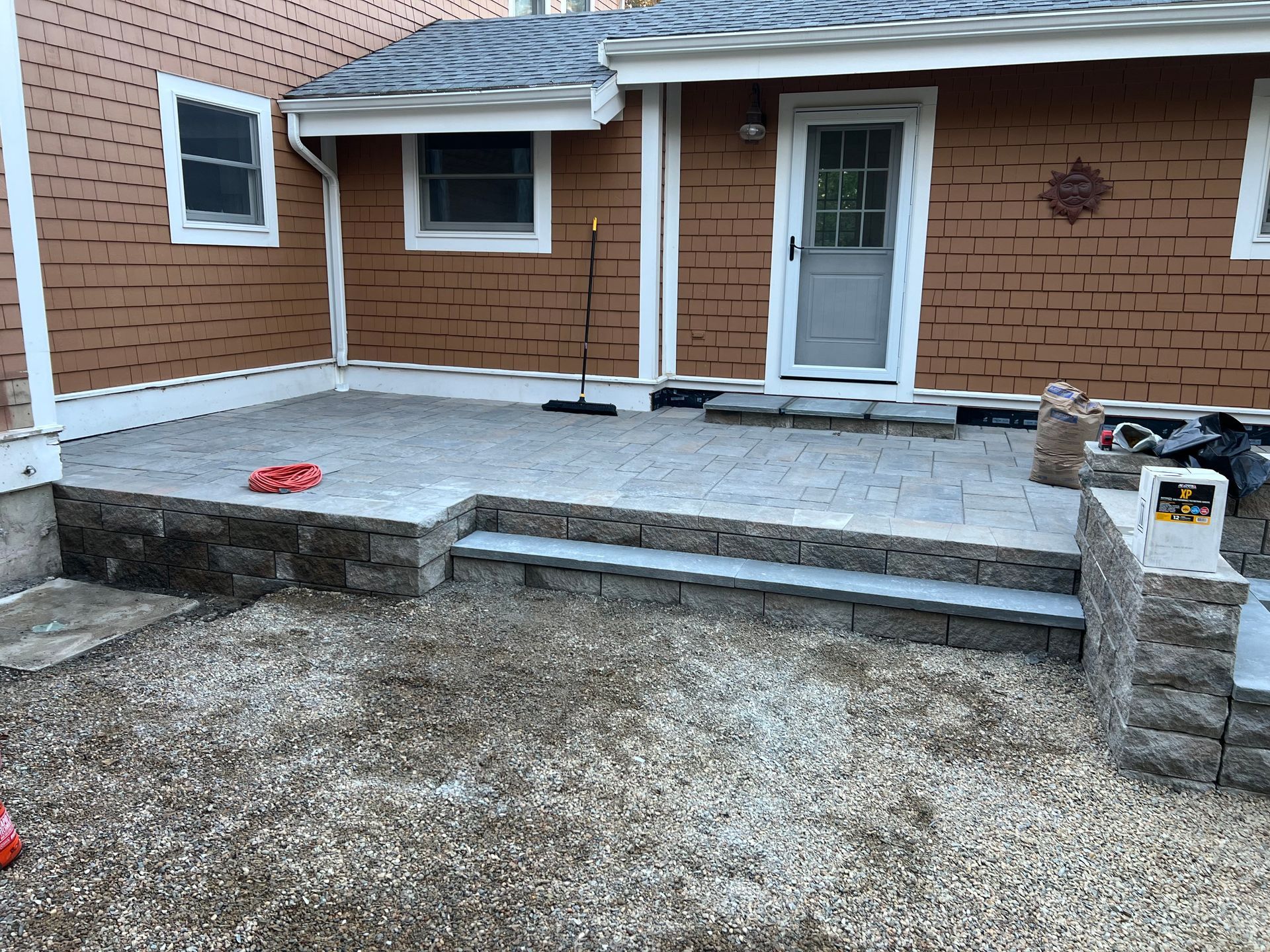 A brick house with a patio and stairs in front of it