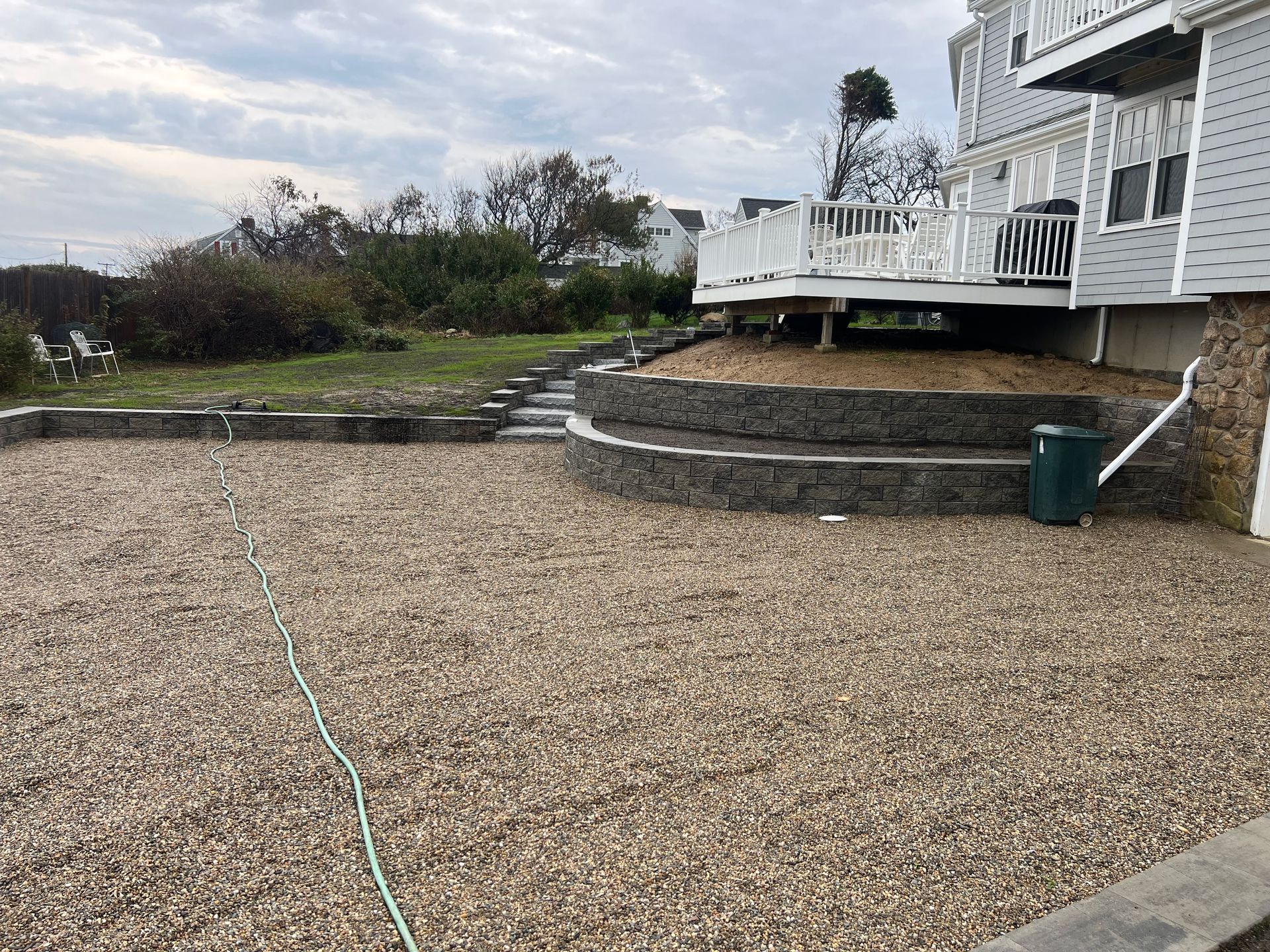 A gravel yard with a house in the background