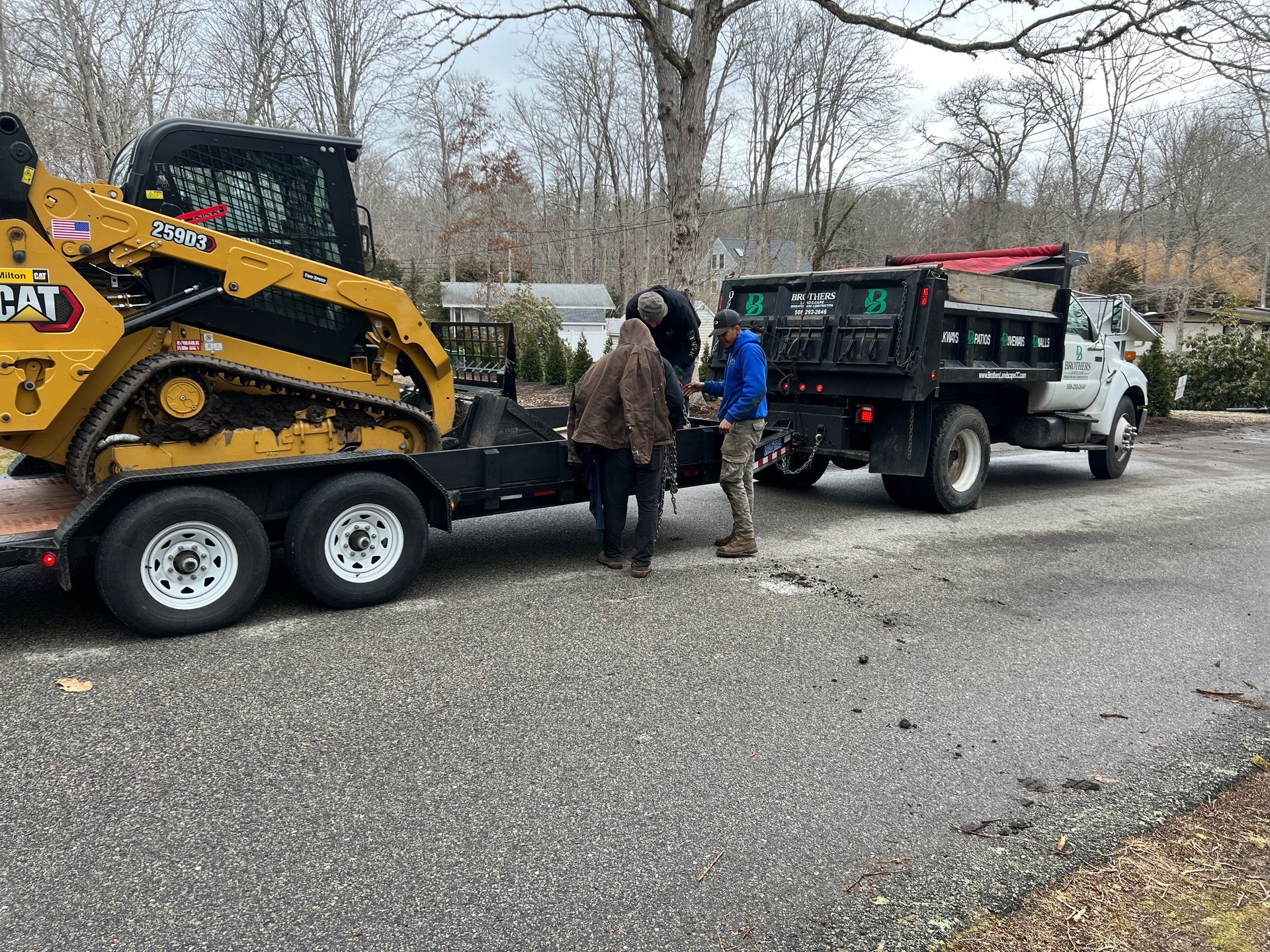A group of people are standing next to a truck and a trailer