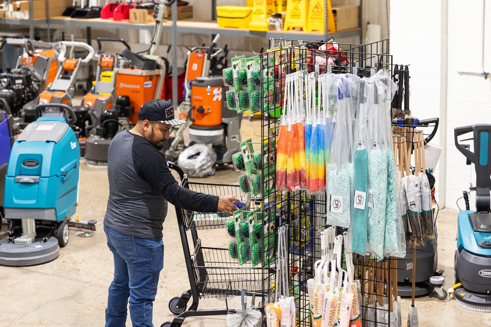 A man is pushing a shopping cart in a store.