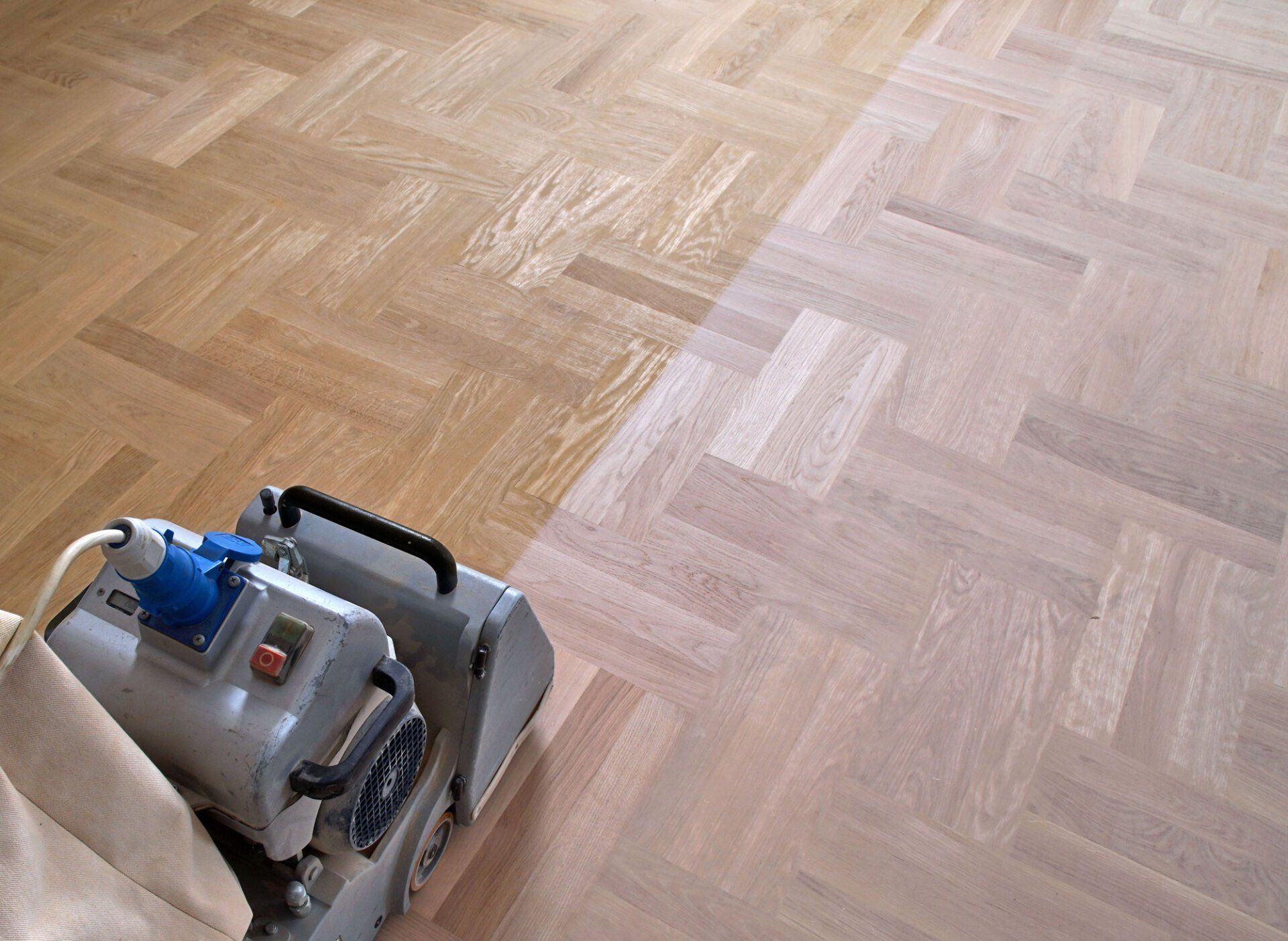 A machine is being used to sand a wooden floor