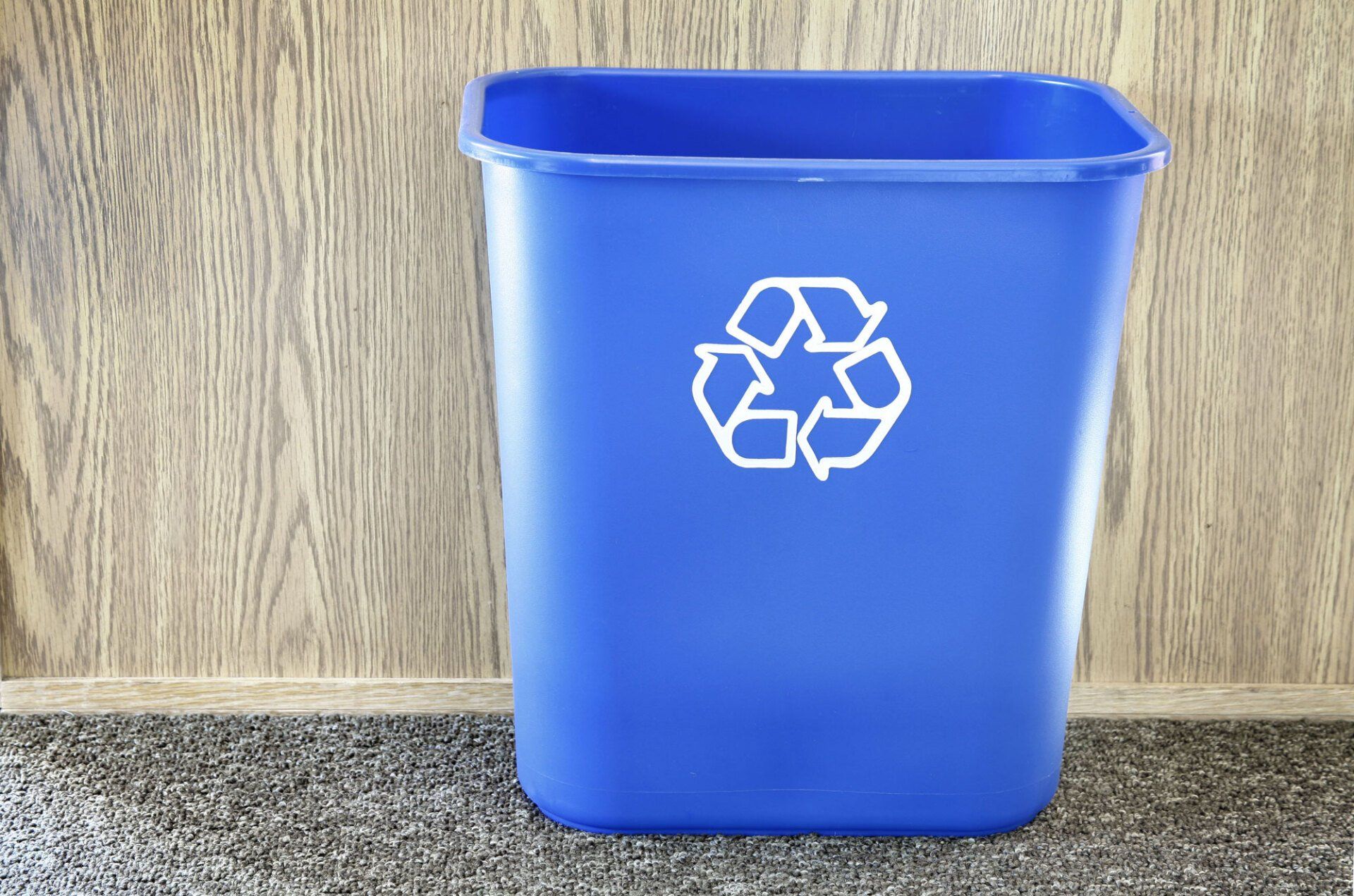 A blue recycling bin with a white recycling symbol on it