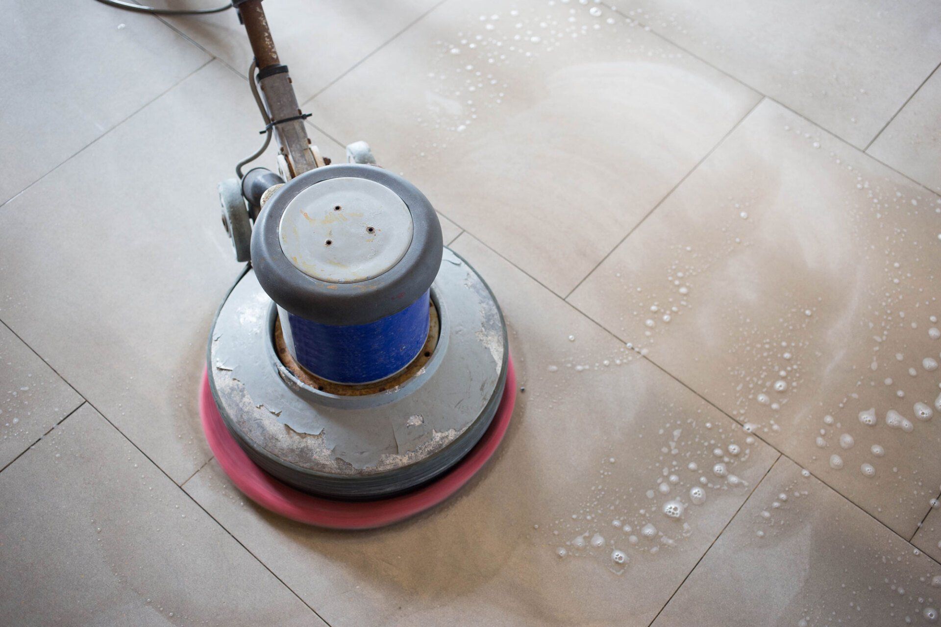 A machine is being used to clean a tile floor.