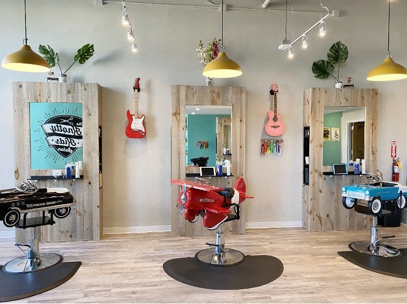 A barber shop with a red airplane shaped chair in the middle of the room.