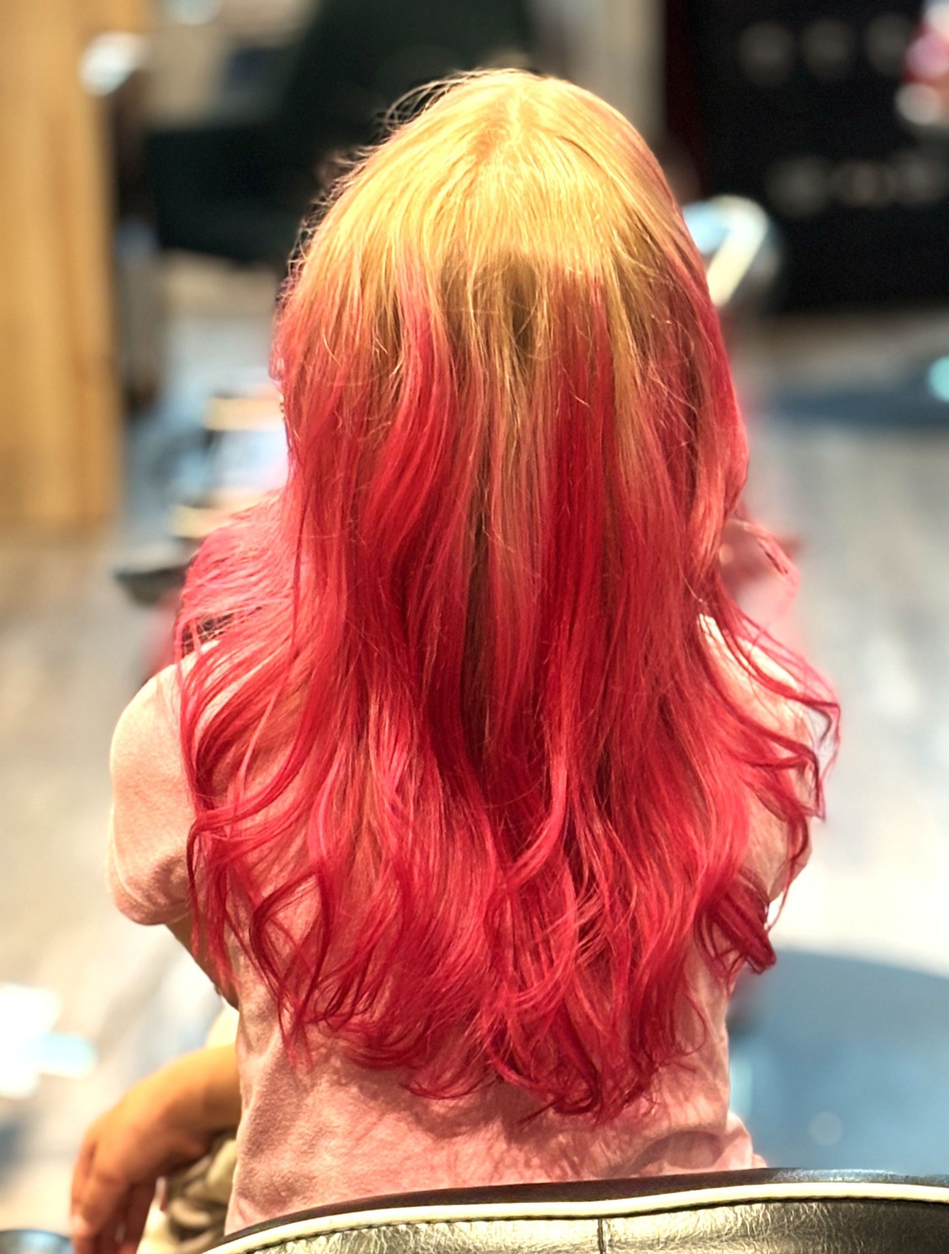 A woman with red hair is sitting in a chair in a salon.