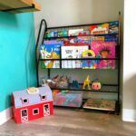 A bookshelf filled with books and toys in a room.