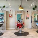 A barber shop with a lot of chairs and guitars on the wall.