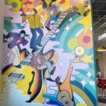 A colorful painting of people playing musical instruments on a wall.