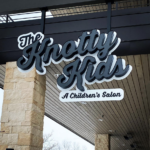 A sign for the knotty kids a children 's salon