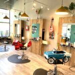 A hair salon with a toy car in the middle of the room.