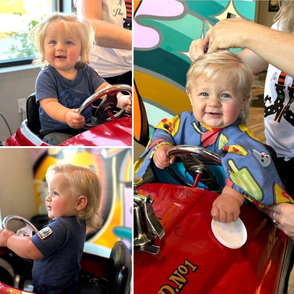 A little boy is getting his hair cut in a red toy car
