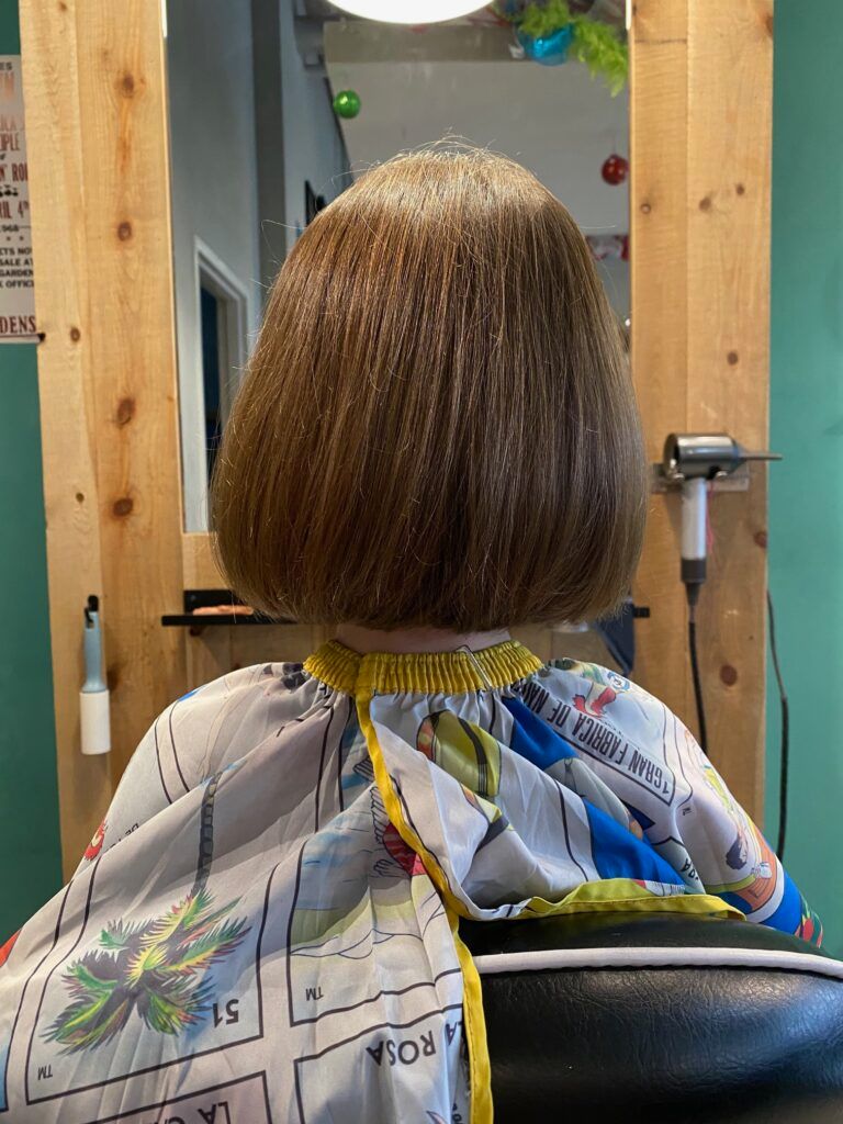 A person is getting their hair cut in a salon.